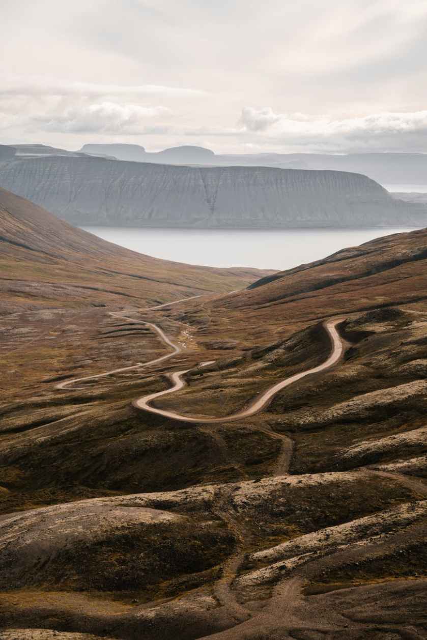 road leading to mountains with lake in valley